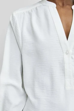 Blusa fluida com decote em bico confecionada com materiais reciclados.