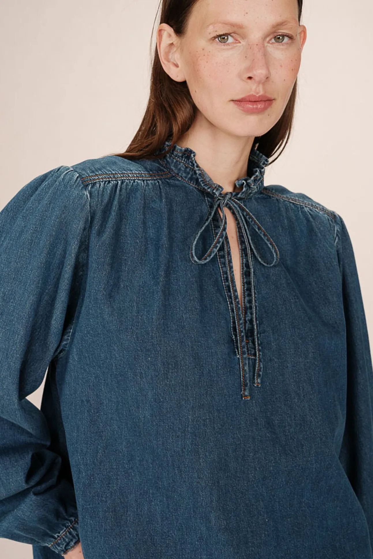 Blusa jeans de manga longa com detalhe de folho e laço no gola