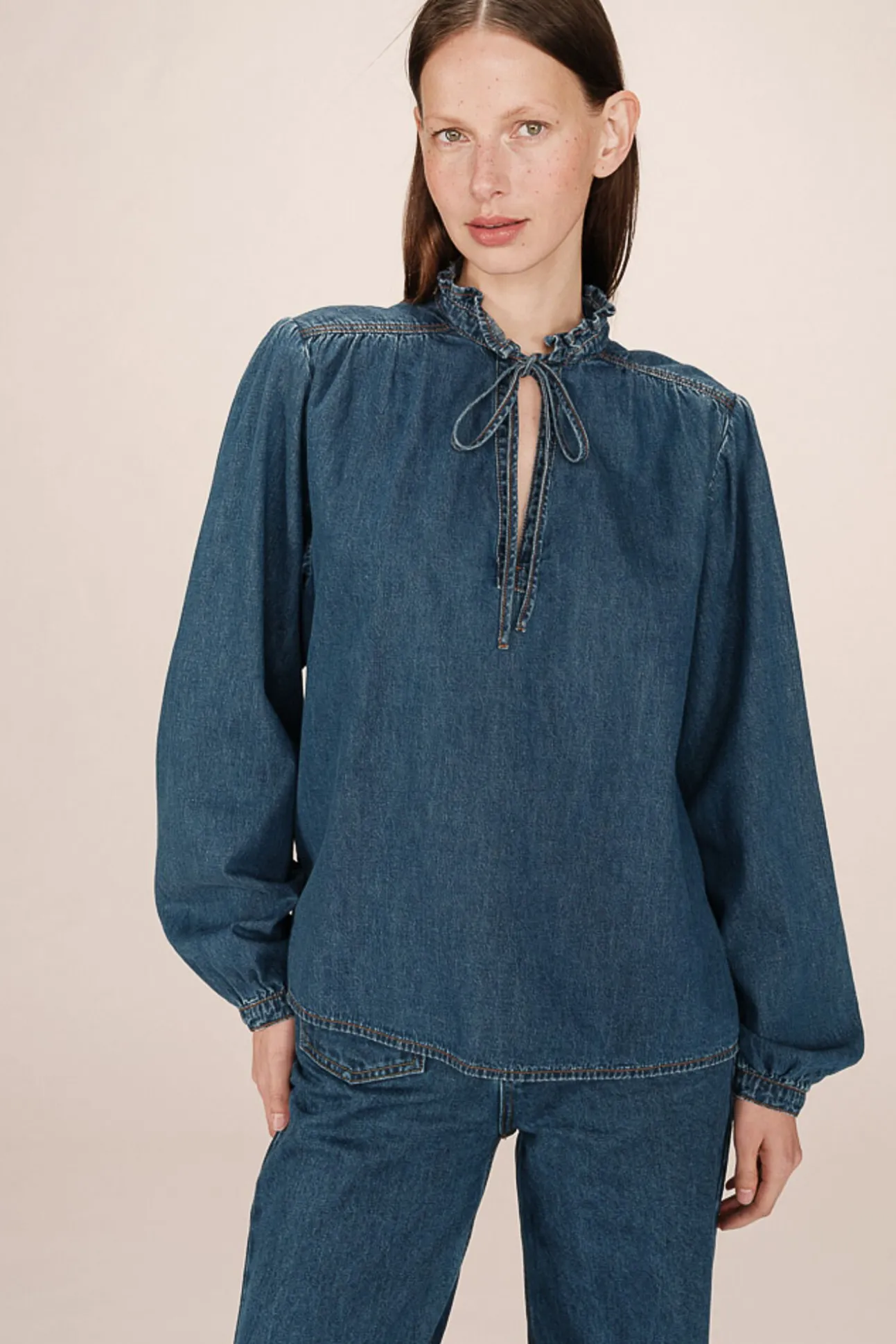Blusa jeans de manga longa com detalhe de folho e laço no gola