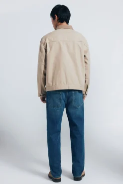 Calça jeans reta com lavagem escura e tingimento excessivo