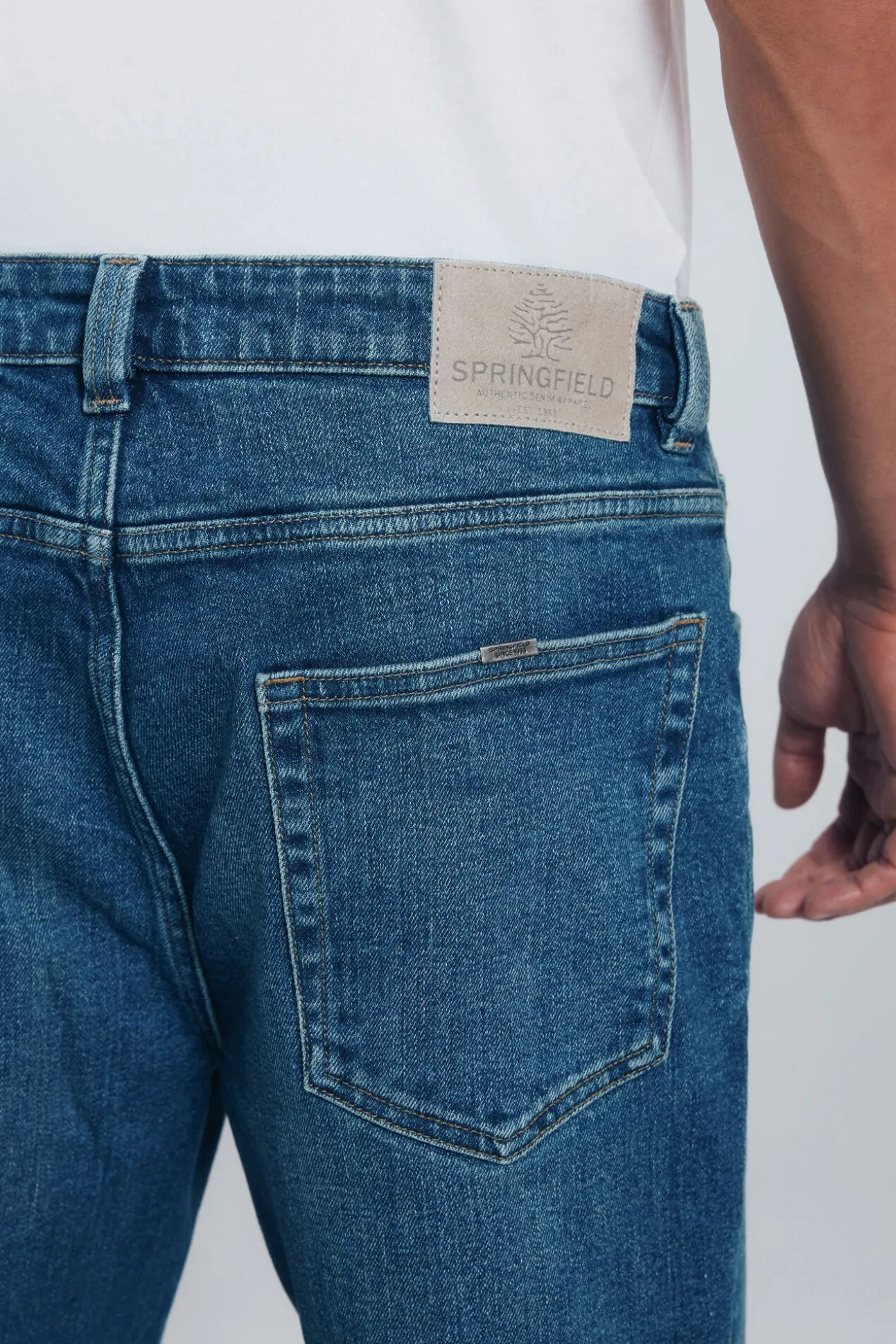 Calça jeans reta com lavagem escura e tingimento excessivo