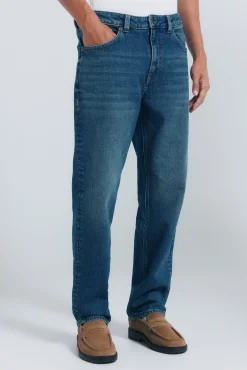 Calça jeans reta com lavagem escura e tingimento excessivo
